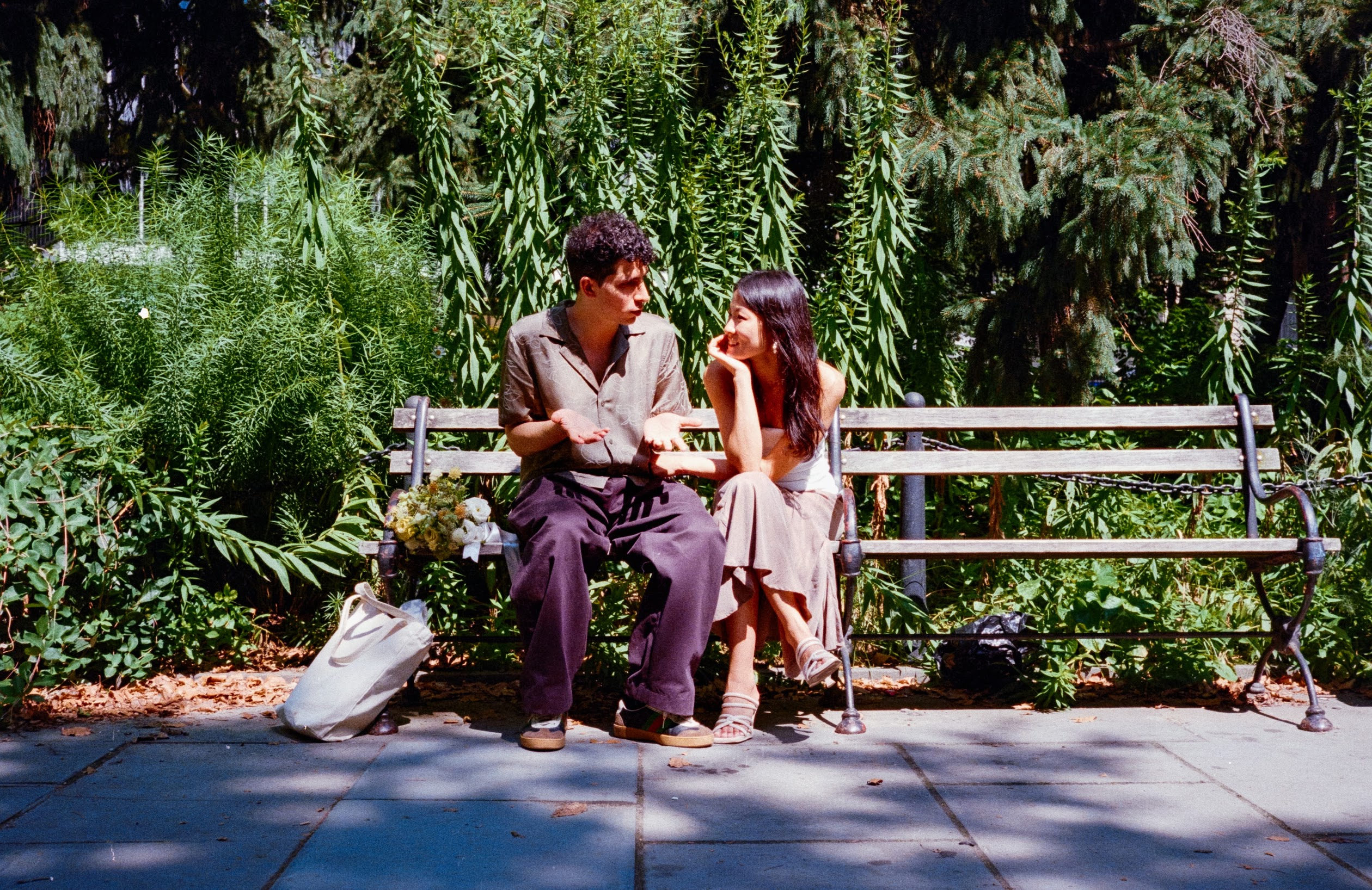 Kelly and Pedram sitting together on a park bench